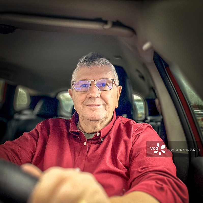 一位年长的白人男性坐在车内图片素材