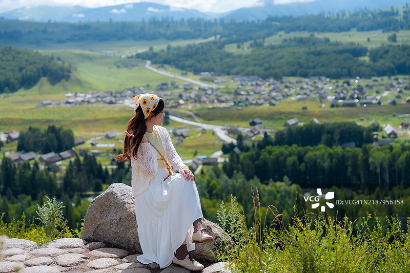 一位亚洲女性在中国新疆禾木村的山顶欣赏风景图片素材
