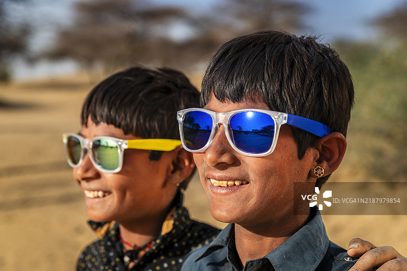 印度年轻男孩戴着太阳镜，沙漠村庄，印度图片素材