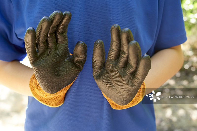 农民展示戴着保护性园艺手套的手图片素材