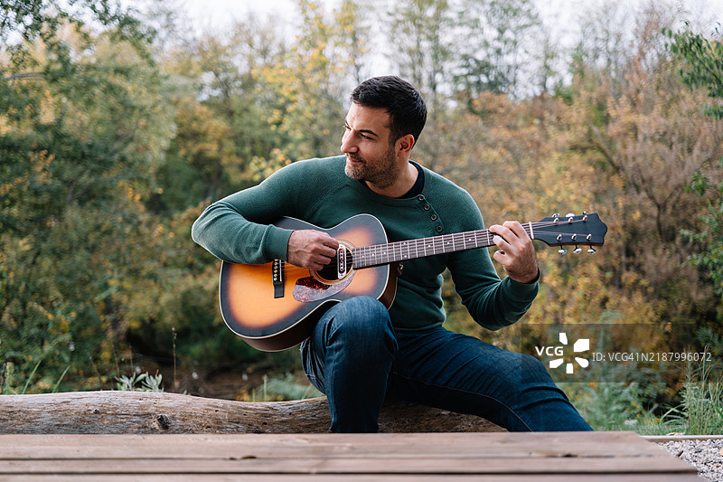 年轻男子在户外弹吉他图片素材