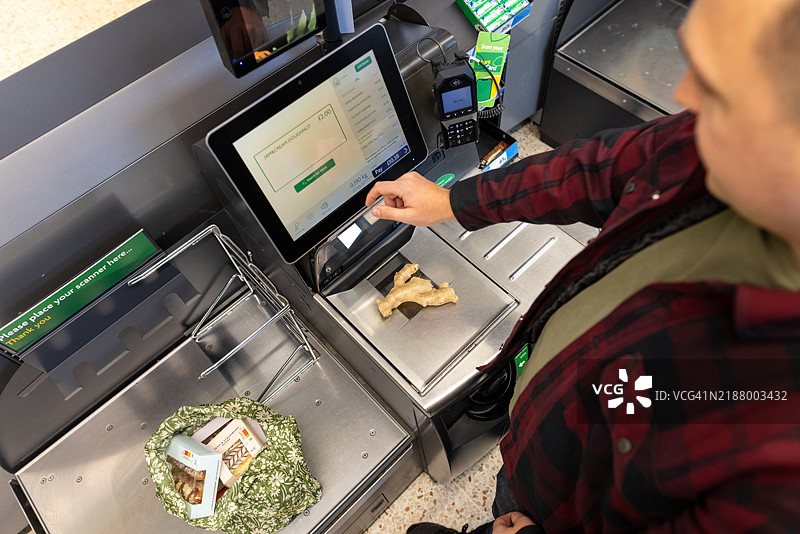 自助结账机前的男子图片素材