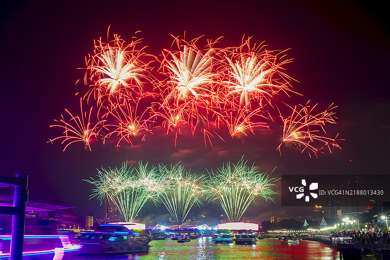 人群在城市建筑上空观看五彩缤纷的烟花绽放图片素材