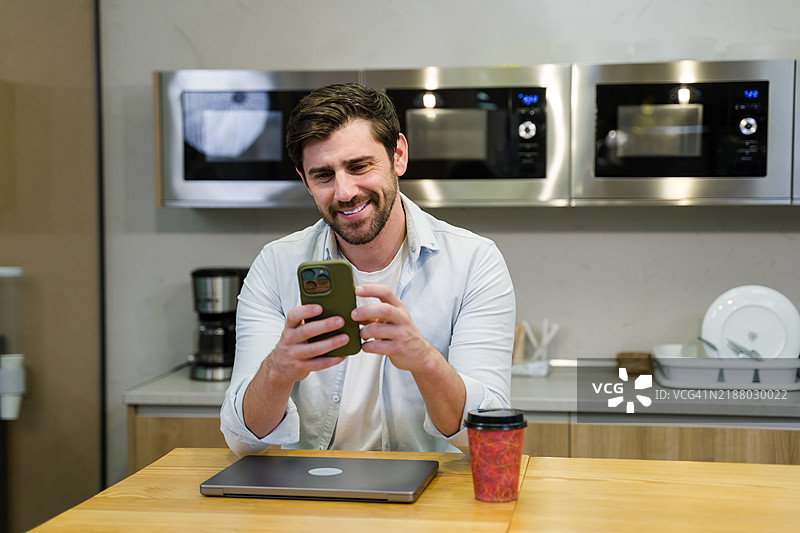 销售员在厨房电器店的咖啡休息时间使用手机图片素材