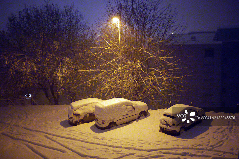 夜间三辆被雪覆盖的汽车的俯视图图片素材