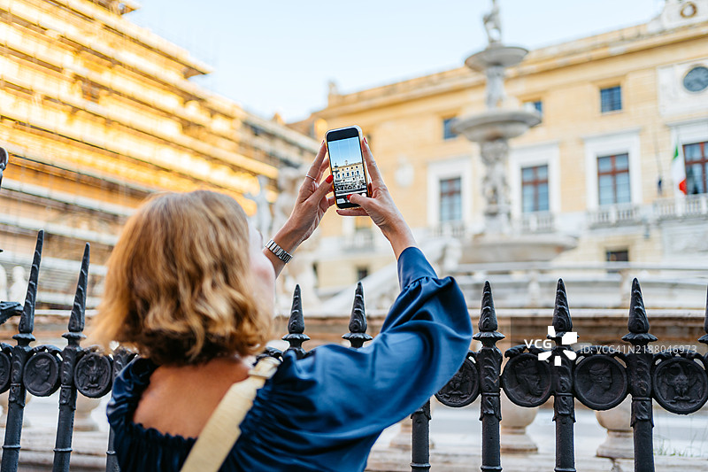 中年女性在西西里巴勒莫的普雷托里亚广场拍摄普雷托里亚喷泉的照片图片素材