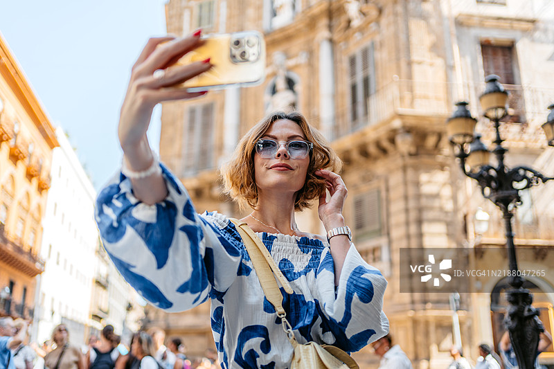 中年女性在西西里岛巴勒莫的四角广场用手机自拍图片素材