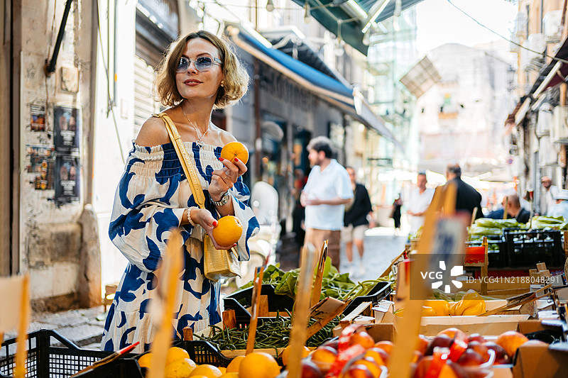中年女性在意大利巴勒莫的街市上购买橙子图片素材