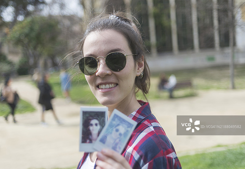年轻女性手持她的宝丽来肖像图片素材