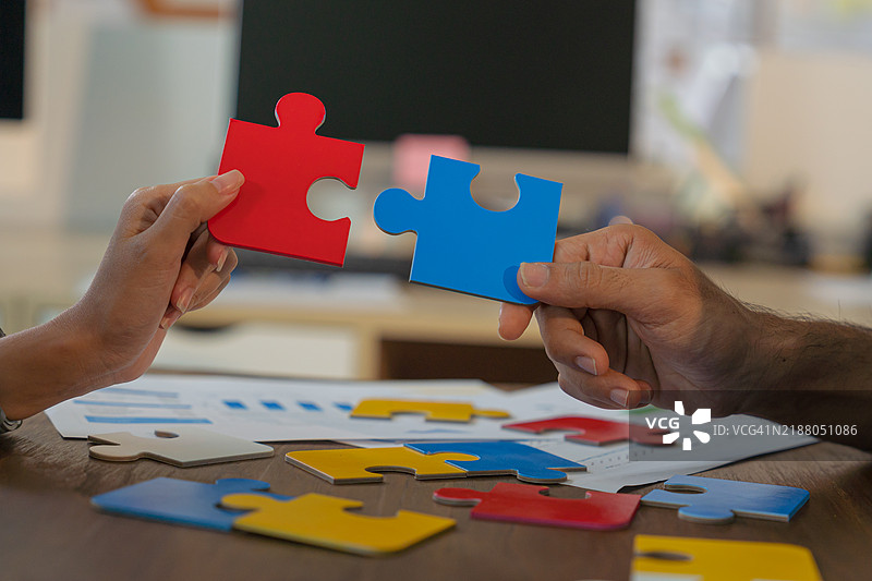 连接。手试图将两块拼图拼合在一起。图片素材