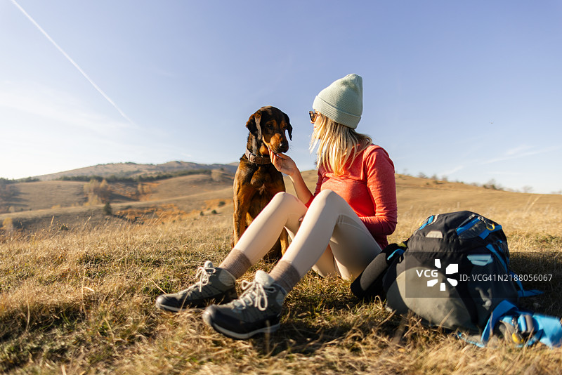 一位女士和她的狗在远足中休息图片素材
