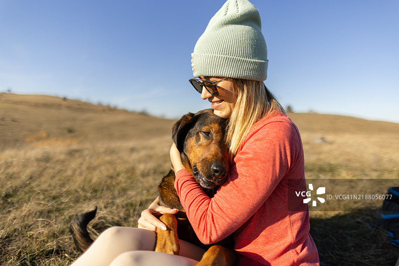 女人和她的狗在远足中休息图片素材