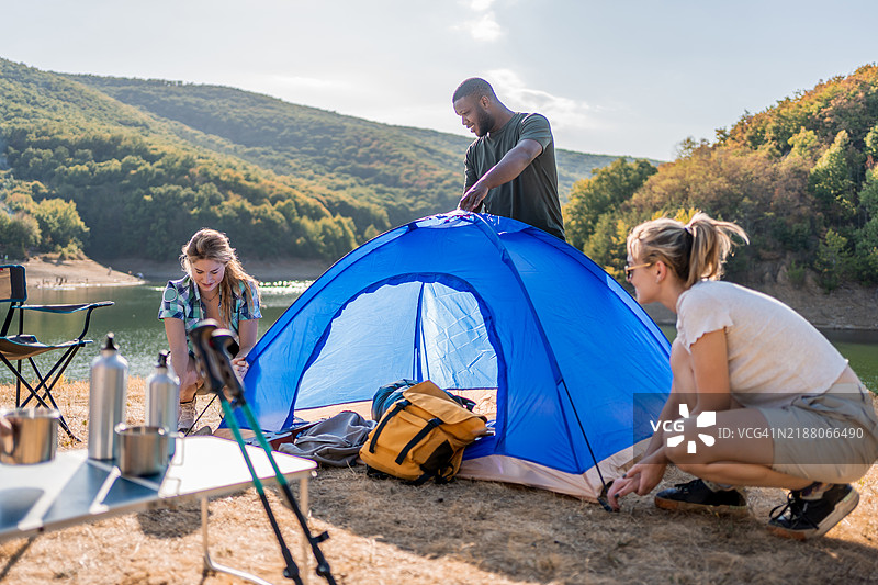 年轻朋友们在湖边搭帐篷图片素材