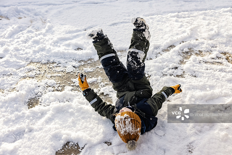 男孩在冰上滑倒图片素材