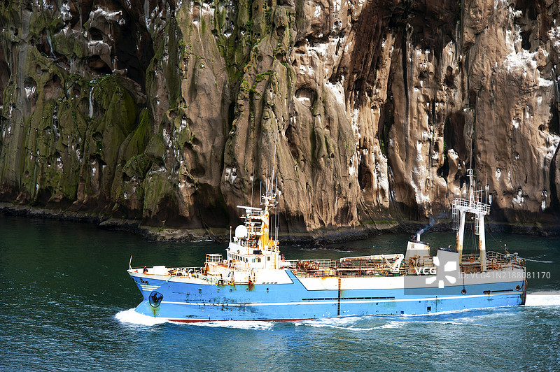 冰岛维斯特曼纳群岛海岸的一艘渔船图片素材