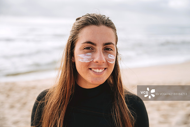 涂抹防晒霜的女性冲浪肖像图片素材