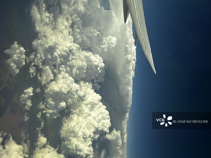 高空视角的飞机在蓬松的云朵中图片素材