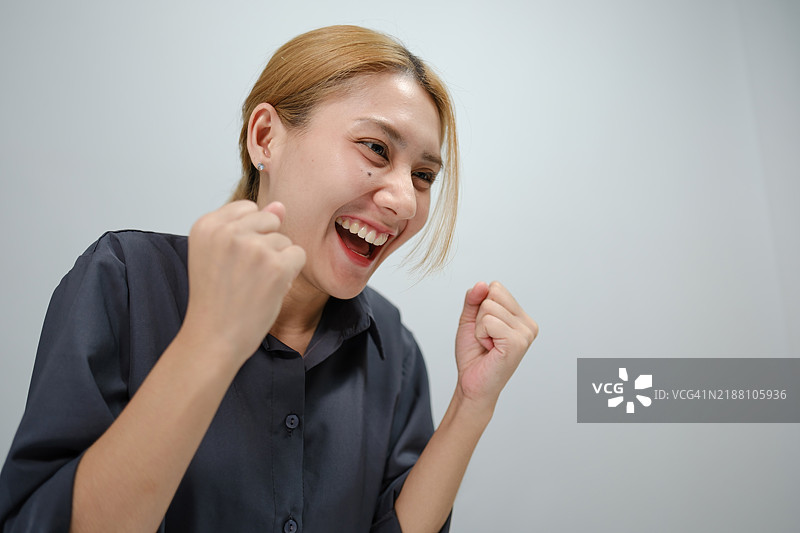 一位女性微笑着，双手举向空中。图片素材