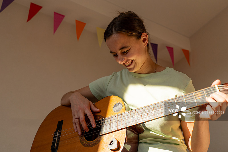女人坐在床上随意弹吉他图片素材
