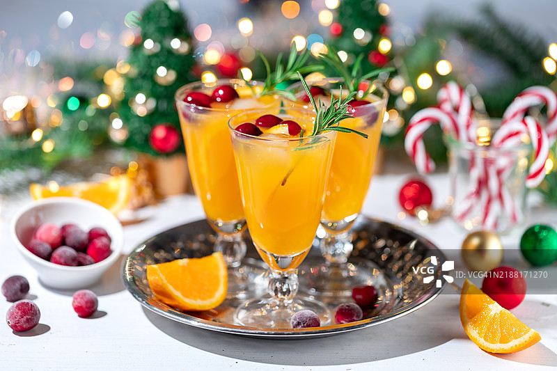 圣诞橙色鸡尾酒，配有蔓越莓、迷迭香和冰块。含酒精和无酒精饮品。图片素材