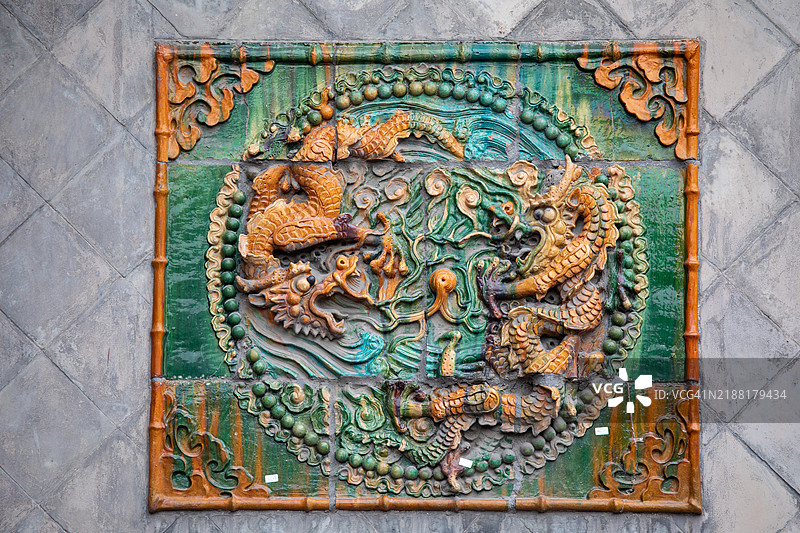 屏风上的方形双龙图案釉面砖。图片素材