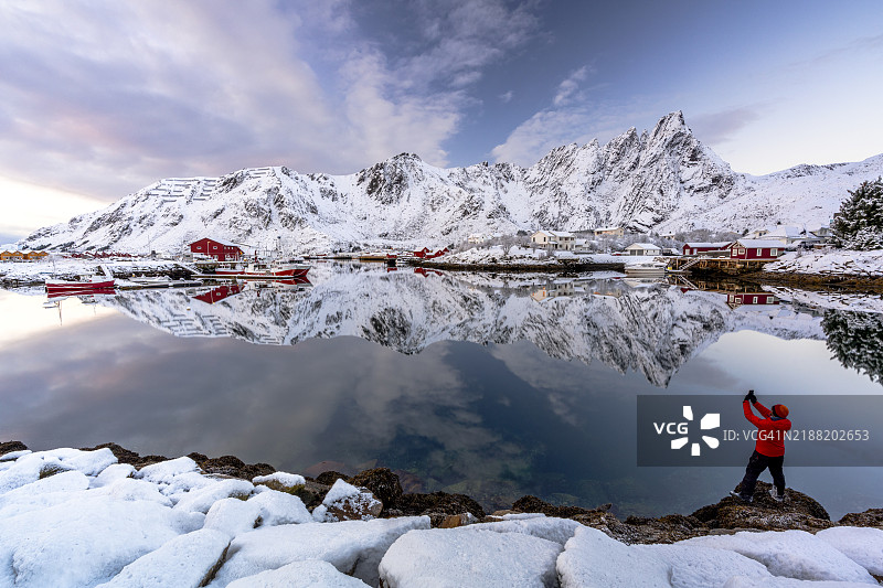 男子用智能手机拍摄渔村图片素材