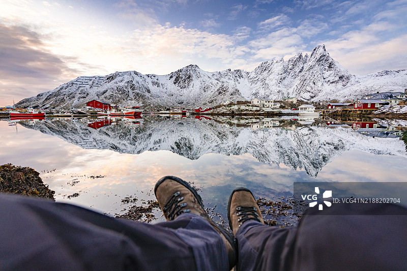 徒步旅行者躺在岩石上观看峡湾日出图片素材