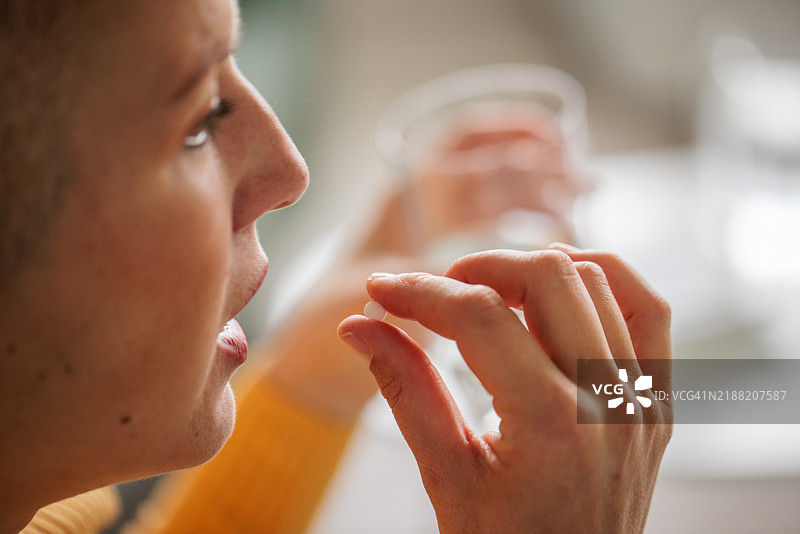 女人将药丸放入嘴中图片素材