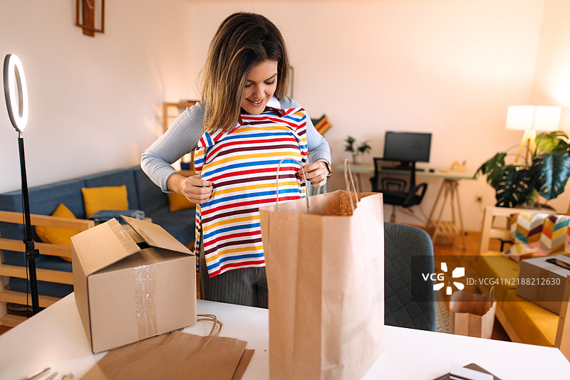 女人在家中拆包。图片素材