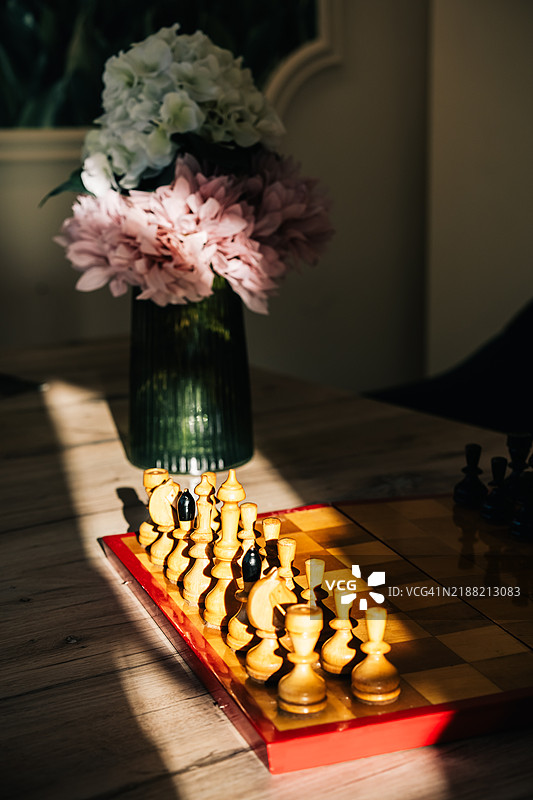阳光明媚的日子里，桌子上摆放着棋盘和棋子图片素材