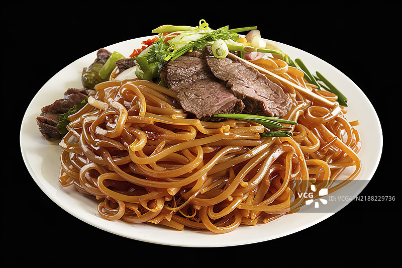 黑色背景上的一盘食物，盘子里盛着光滑的金棕色煮熟的米粉。图片素材