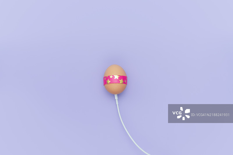 充电的复活节彩蛋与电缆，简单背景图片素材