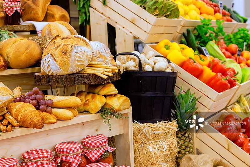 生机勃勃的农贸市场展台，展示新鲜农产品和烘焙食品图片素材