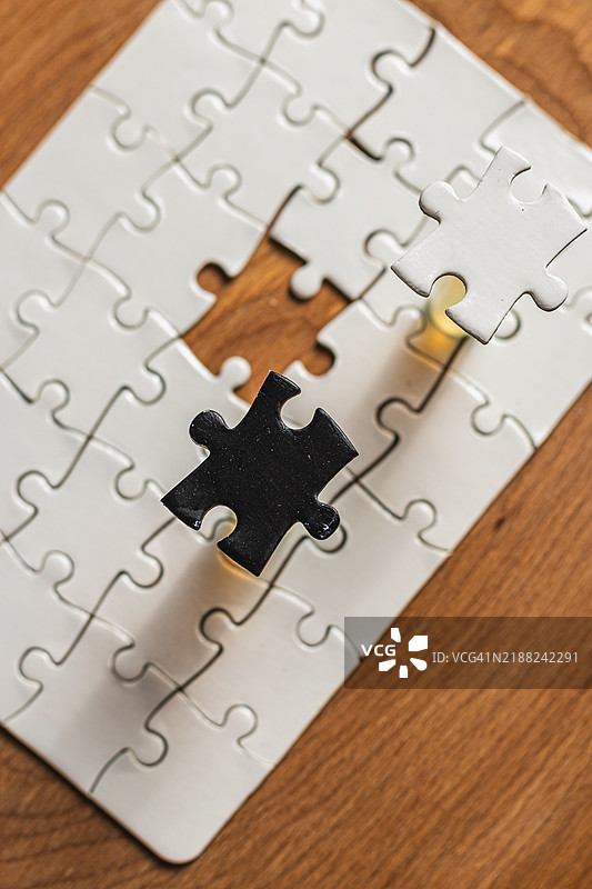 对立日概念，使用白色和黑色拼图块在白色背景上图片素材