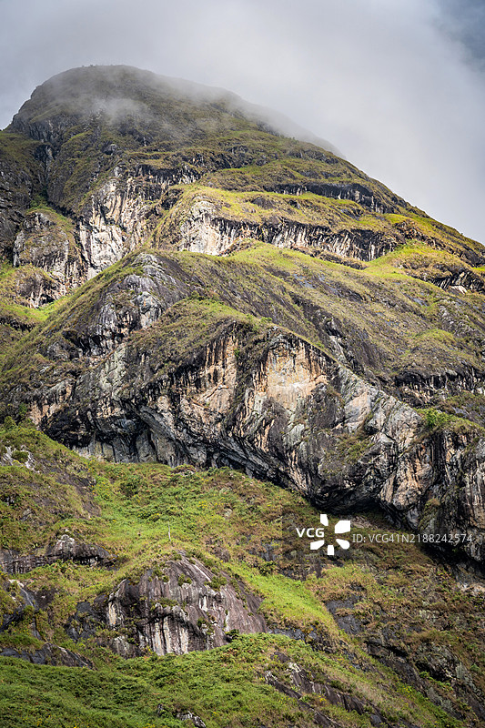 哥伦比亚安第斯山脉的山顶，岩石和草地在日落的光辉下，雾气在山坡间弥漫，美丽而神奇的风景，邀请你去冒险。图片素材