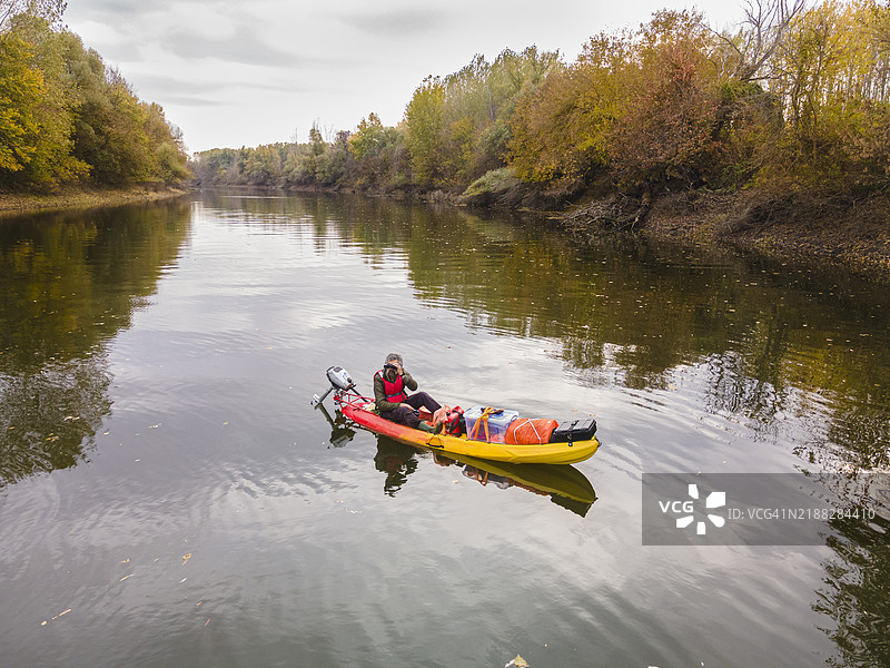 热带雨林河流中划皮艇的鸟类观察者，鸟瞰图图片素材