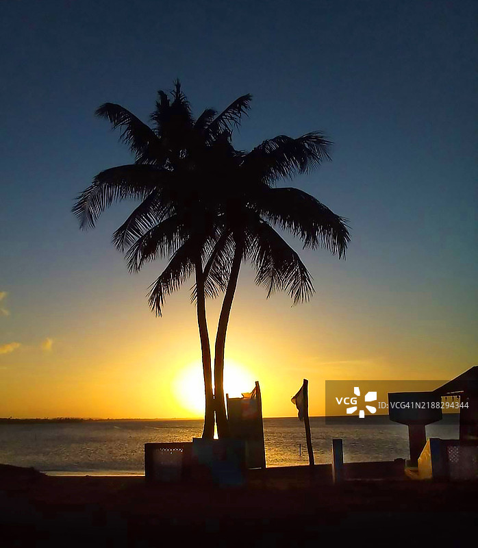 热带海滩的日落，太阳优雅地沉入地平线以下图片素材