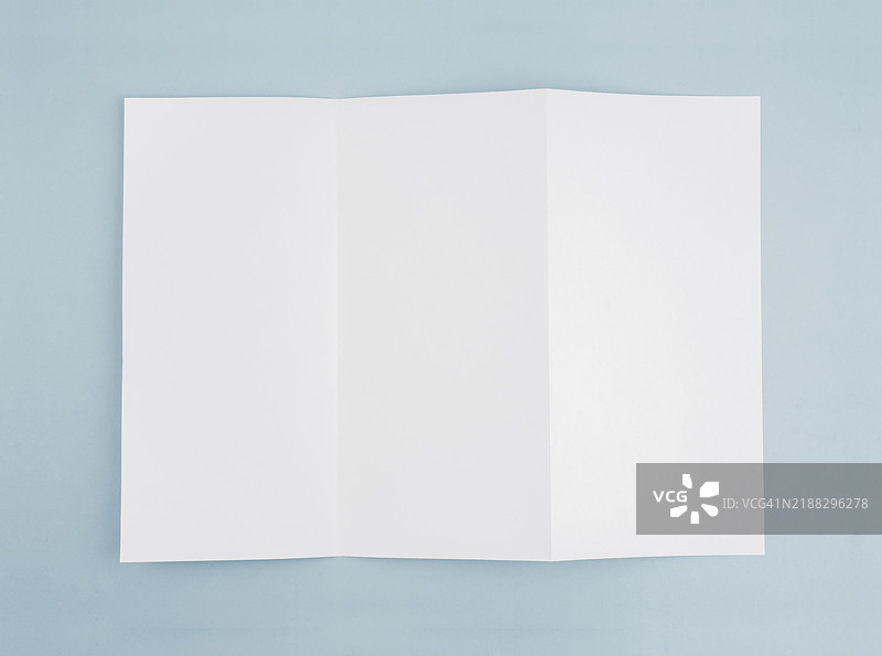 一张空白的三折A4纸，背景为柔和的蓝色，留有空间供您填写文本或信息。图片素材