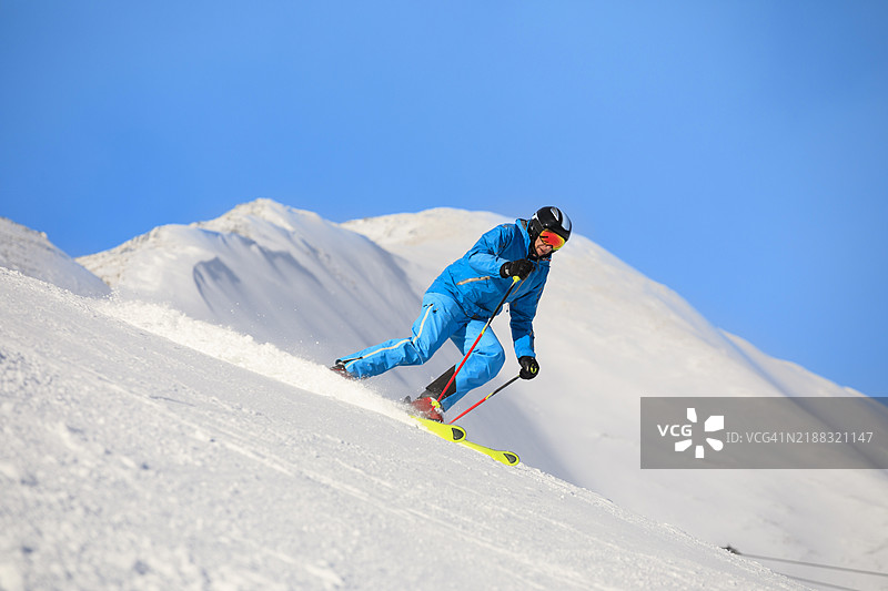 滑雪冬季运动。男子滑雪者在阳光明媚的塞拉隆达滑雪度假村享受滑雪乐趣。多洛米蒂超级滑雪区的雪山。图片素材