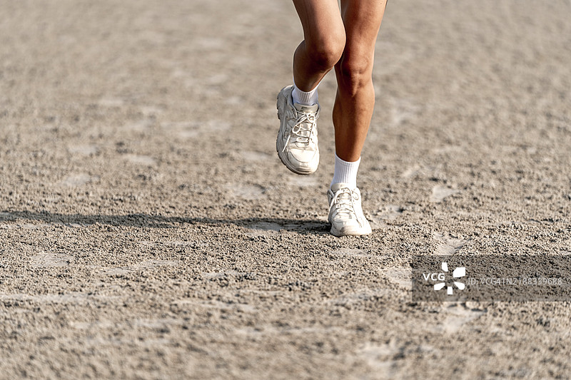 美丽的女人在海滩上跳跃，背景是大海和修长的腿图片素材