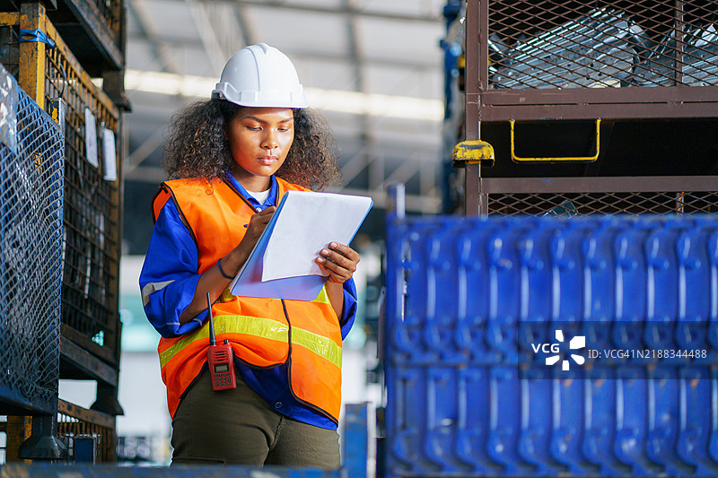 女性仓库工人在配送仓库进行库存审计。图片素材