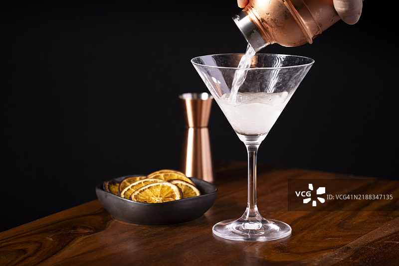 马提尼鸡尾酒从摇酒器中倒出图片素材