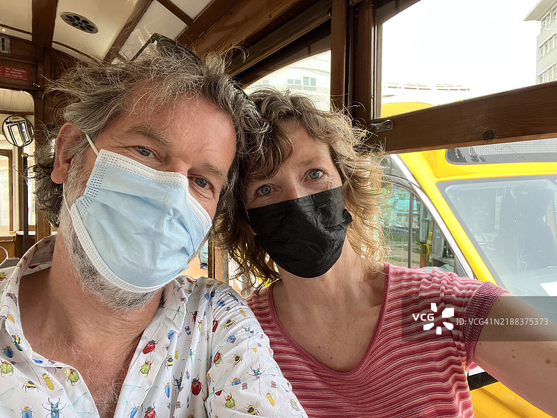 一对成熟夫妇在里斯本的缆车上自拍图片素材