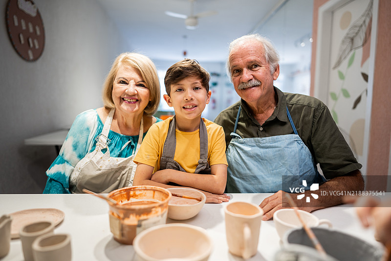 一家人在陶艺工作室上陶瓷课的肖像图片素材