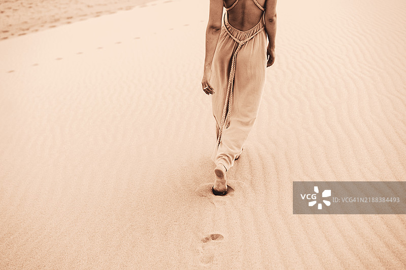 优雅的极简主义：赤脚走在摩卡棕色沙丘上的女性。2025年的颜色图片素材