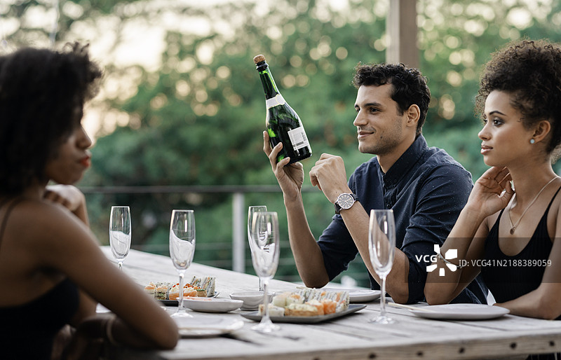 优雅的户外寿司晚宴，朋友们在日落时分举杯庆祝图片素材
