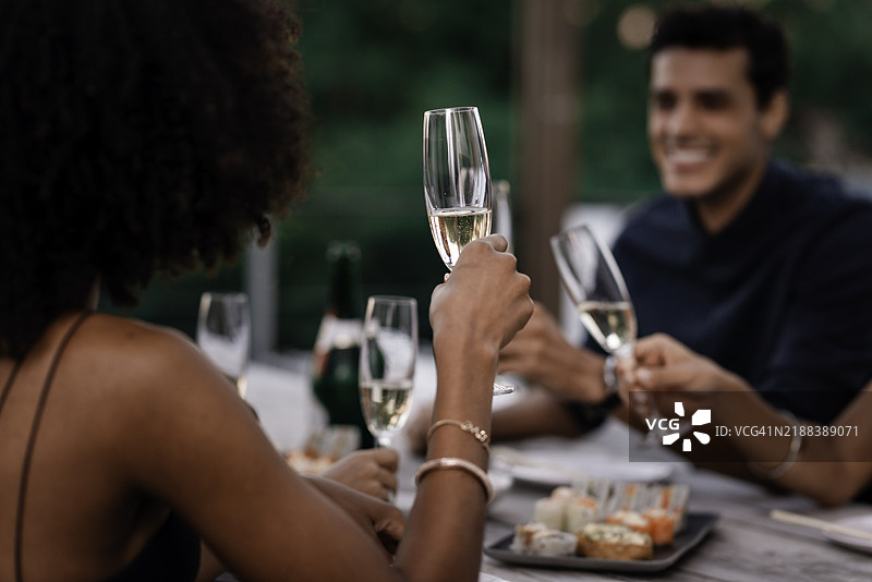优雅的寿司晚宴，朋友们在轻松的户外环境中举杯庆祝香槟图片素材