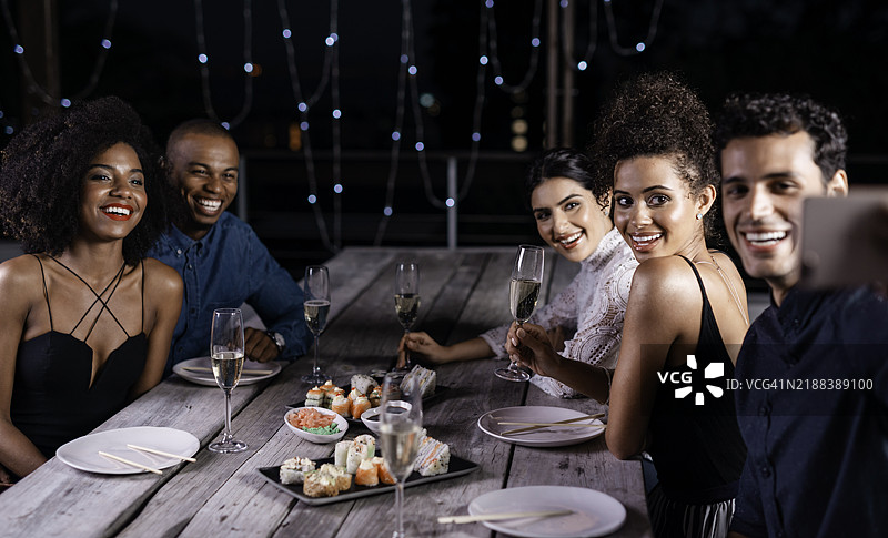 精致的户外晚宴派对，朋友们在星空下享用寿司和香槟图片素材