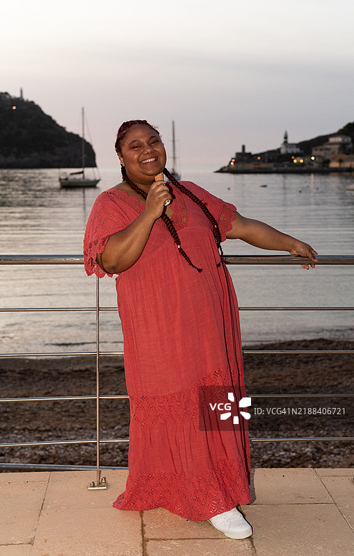 游客在海边日落时吃冰淇淋图片素材