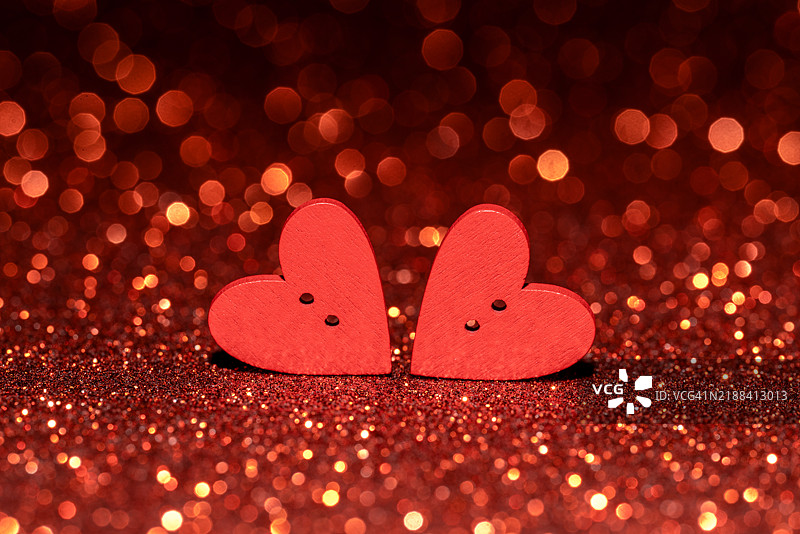 红色心形在闪亮的背景上闪耀，适合浪漫的情人节庆祝活动图片素材